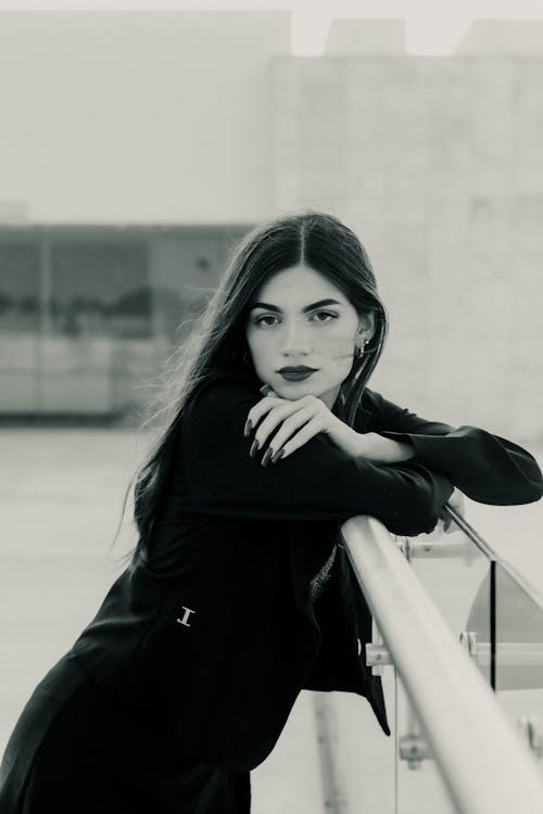 Black and White Photo of a Young Brunette Woman Posing in Black Blazer and Skirt