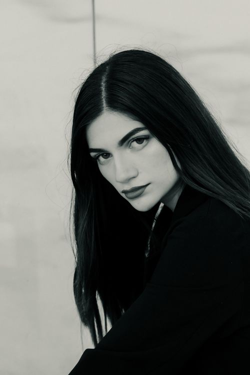 Free Black and white portrait of a woman with long brunette hair looking at the camera. Stock Photo