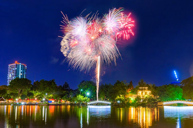 Fireworks Over Lake In Park At Night