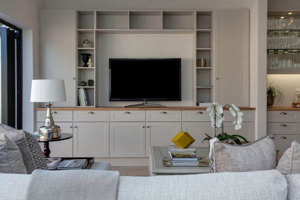 Flat screen TV on its stand in a living room wall unit, ready to be unplugged and packed for moving