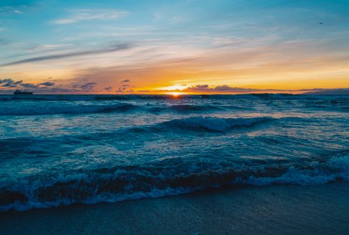 Free Beautiful ocean sunset with choppy waves and vibrant sky colors, perfect for peaceful moments. Stock Photo