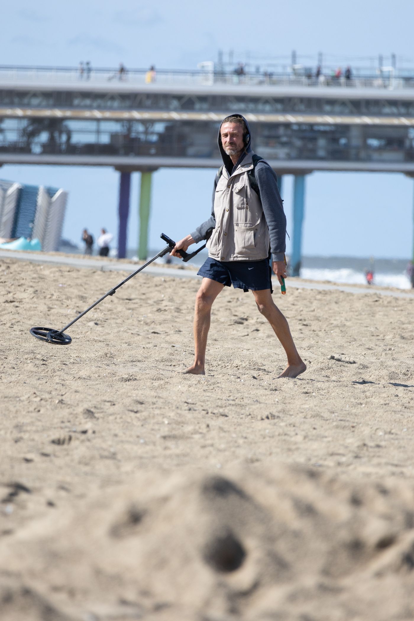 Person using a metal detector on a sandy beach
