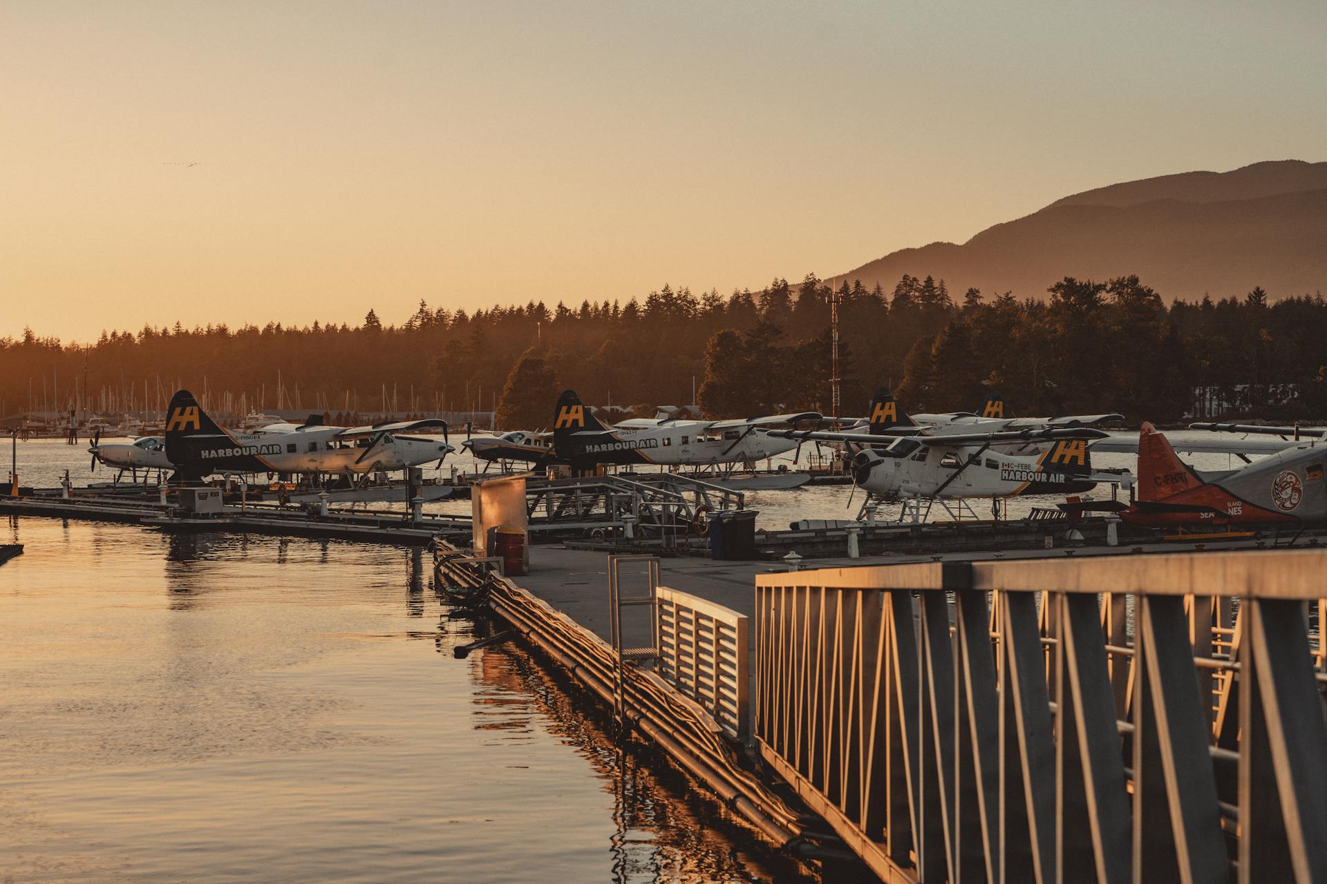 Seaplanes at sunset on Vancouver's waterfront pier, offering travel and scenic beauty.