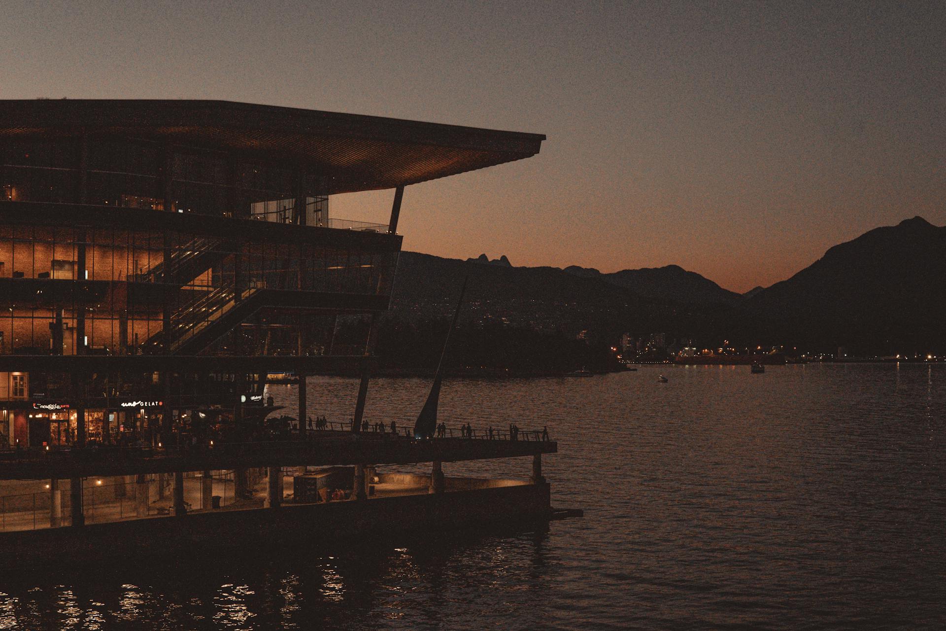 Stunning sunset view of a modern Vancouver building by the water, showcasing the city's skyline.