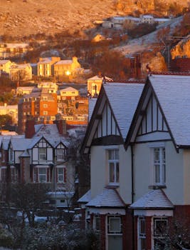 Charming winter scene with snow-dusted traditional houses and distant hills