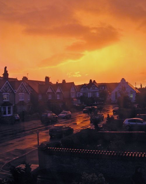 Free Beautiful suburban homes under a vibrant sunset sky, capturing the essence of peaceful evening ambience. Stock Photo