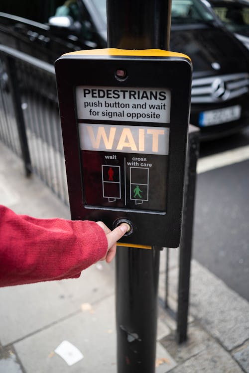 Photo of Person Pressing the Button of Pedestrian Box