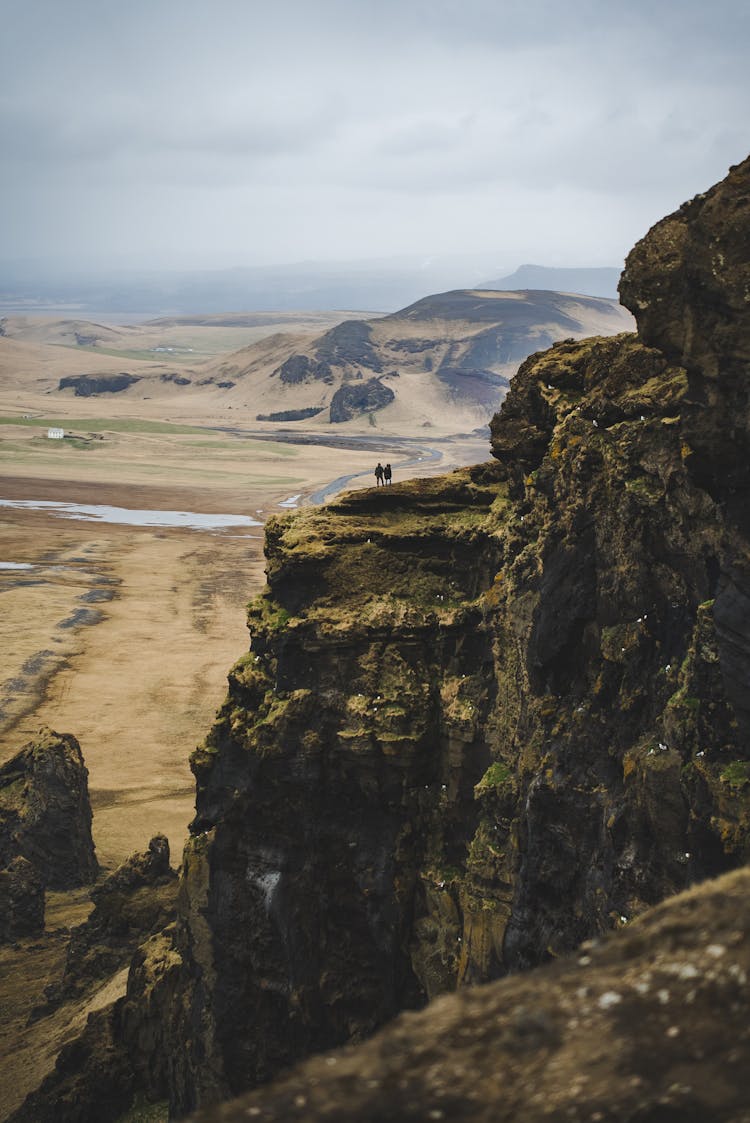 People On Green Rocks Over Plains