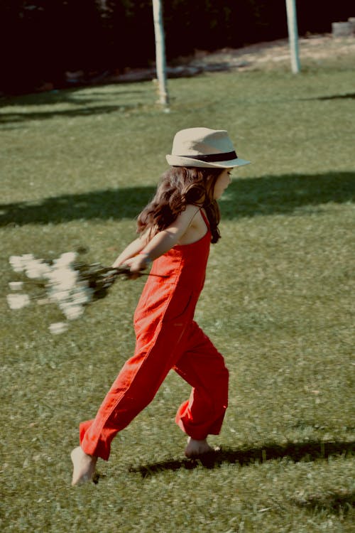 A Girl with Flowers Running on the Grass