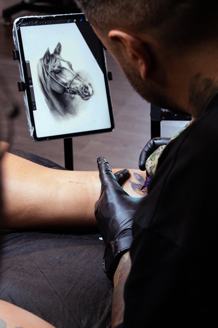 Tattooist Making Tattoo Of Horse Head