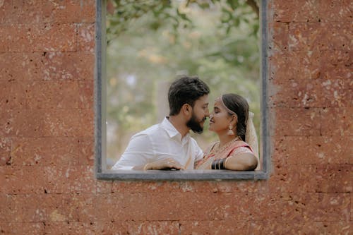 Newlyweds Kissing in Window