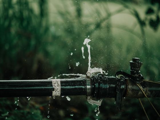 Water running from a split in an old metal pipe