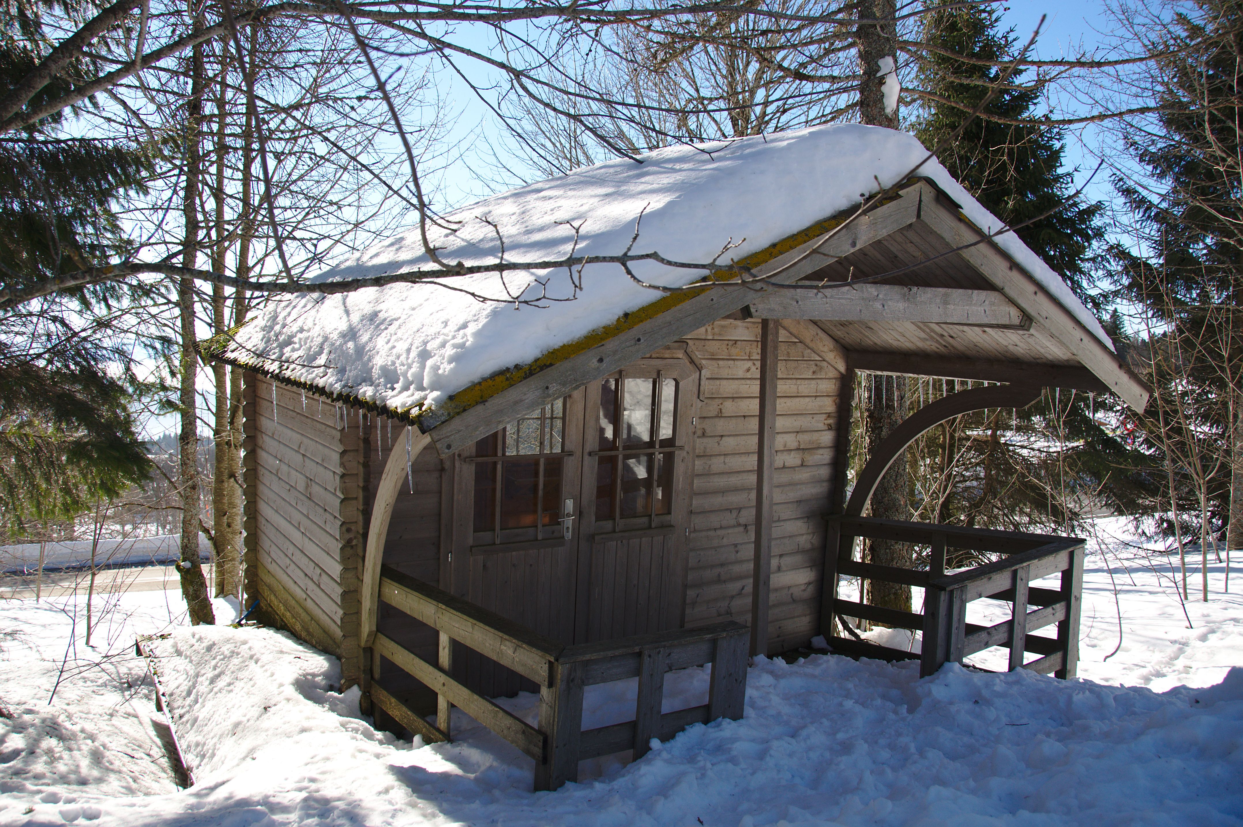 Houten hut in een besneeuwd bos