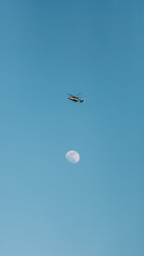 A Helicopter Flying against a Clear Blue Sky 