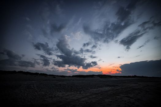 A captivating view of dramatic clouds over a Nantucket beach at sunset.