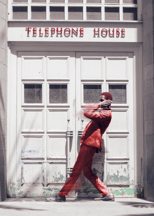 Person in Red Suit Posing by Telephone House