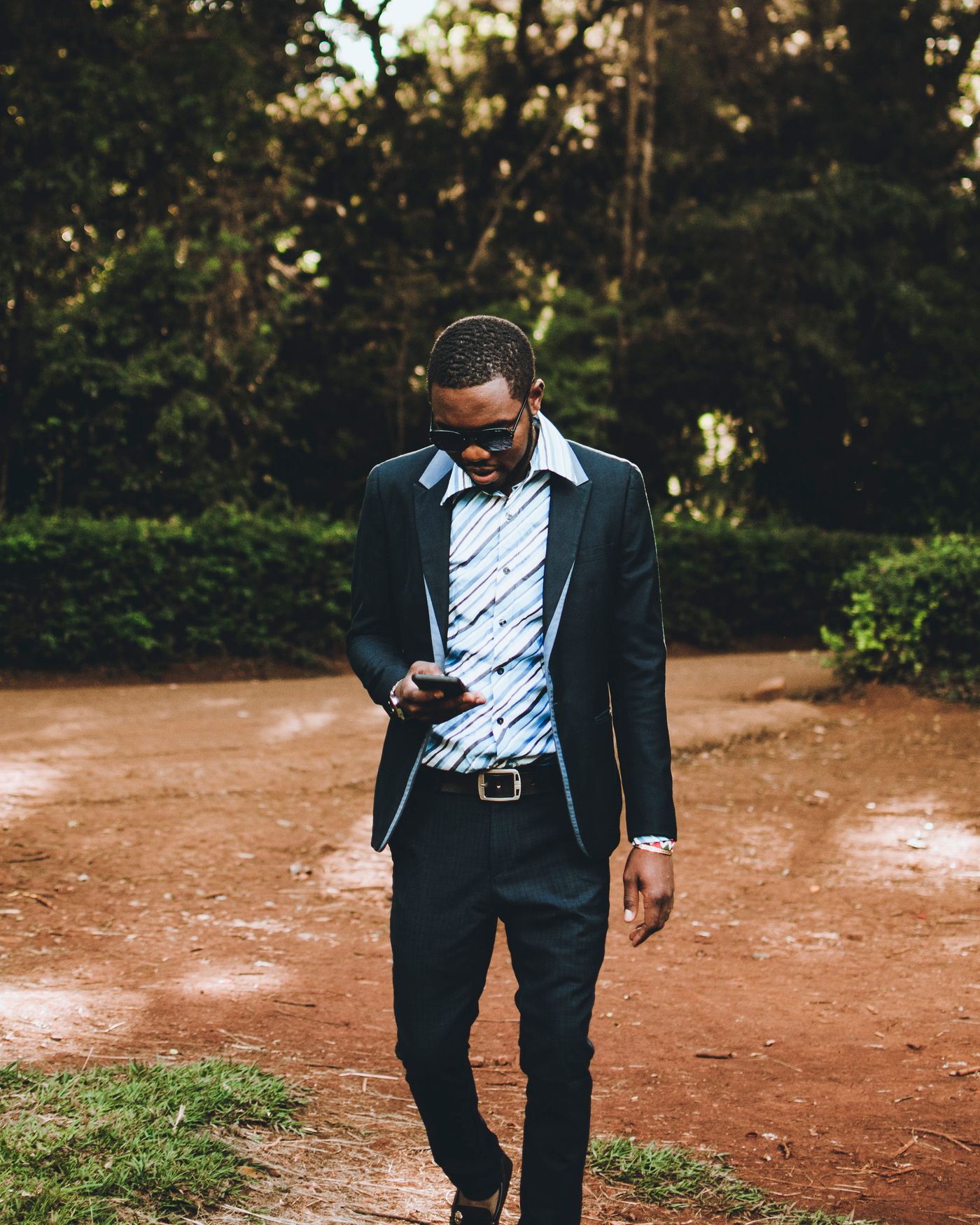 A man outdoors looking at his smartphone.