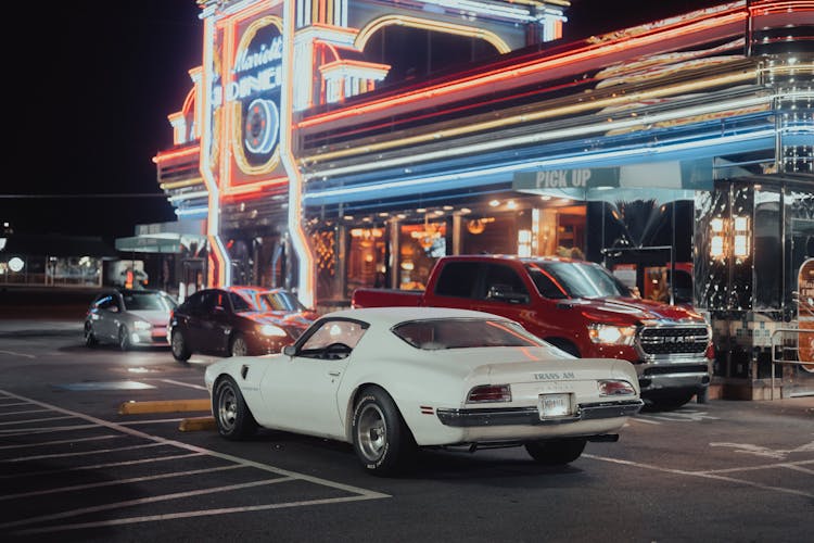 Pontiac Firebird And Cars Near Building At Night