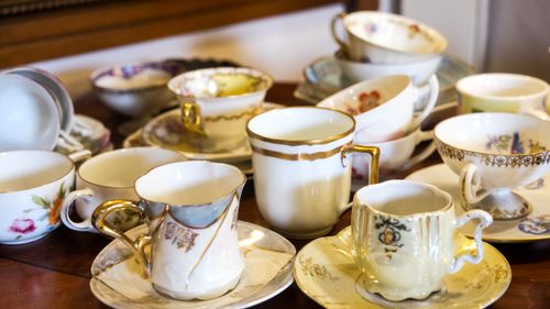 Free A variety of elegant vintage porcelain teacups displayed on a wooden table. Stock Photo