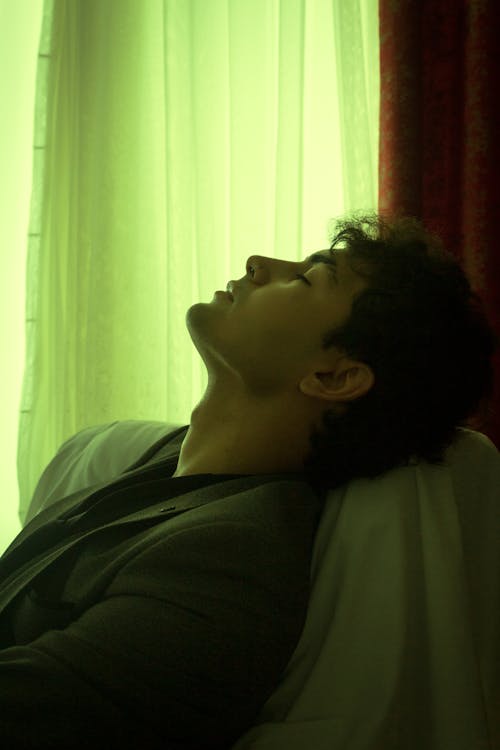 Closeup of a Man Taking a Nap in a Room with Curtains