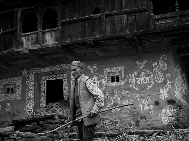 Old Man Near Ornate Traditional House