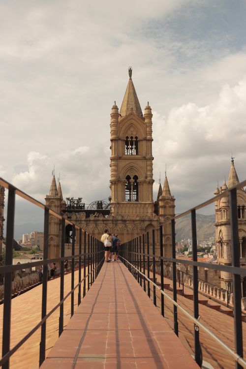 Free Tourists walking along the rooftop path of Palermo Cathedral with a view of its iconic bell towers. Stock Photo