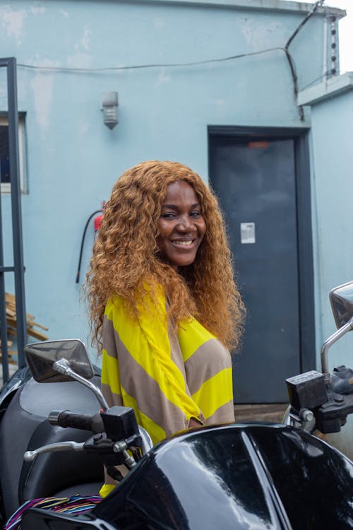 Smiling Woman Standing behind Motorbike