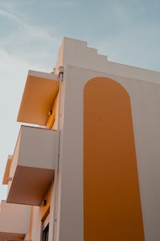 A contemporary apartment building in Albufeira with distinctive orange accents and balconies.