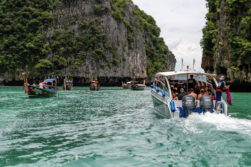 People Sailing between Tall Cliffs