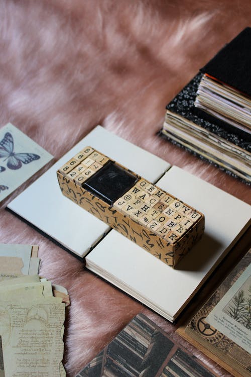 an aesthetic flat lay of junk journaling supplies gathered on top of a  handmade journal surrounded by art props, vintage papers, and dry leaves ·  Free Stock Photo