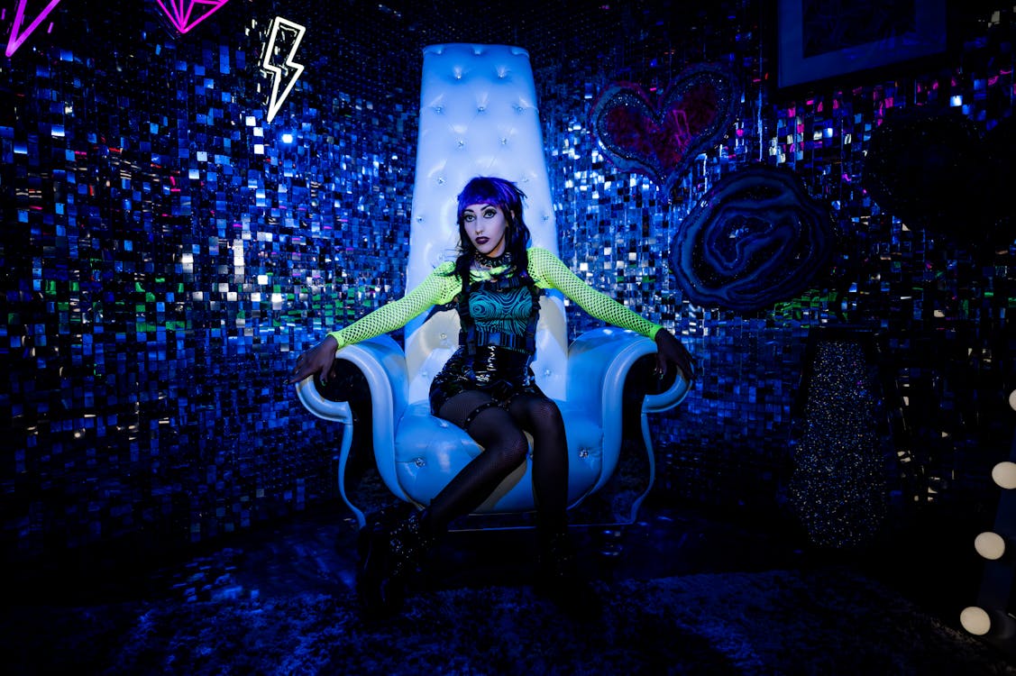 Punk Rock Singer Sitting on a White Armchair with a High Backrest
