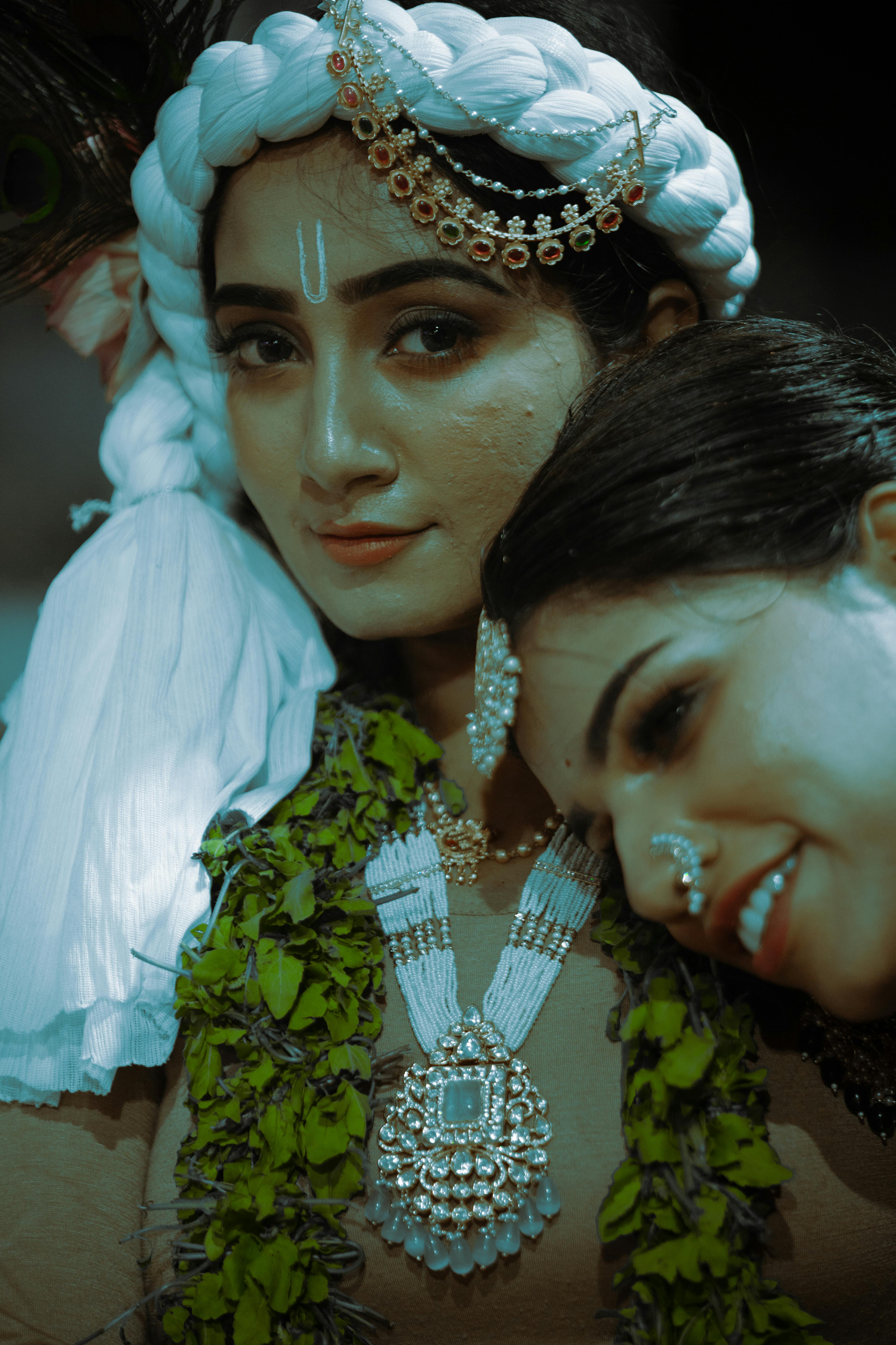 A candid shot of two Indian women in traditional attire celebrating a cultural festival.