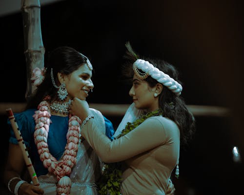 Young Women Wearing Traditional Clothes, Jewelry and Floral Garlands 
