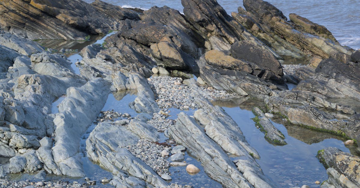 Explore the rugged rocky shoreline of Newcastle, Northern Ireland with clear ocean views.