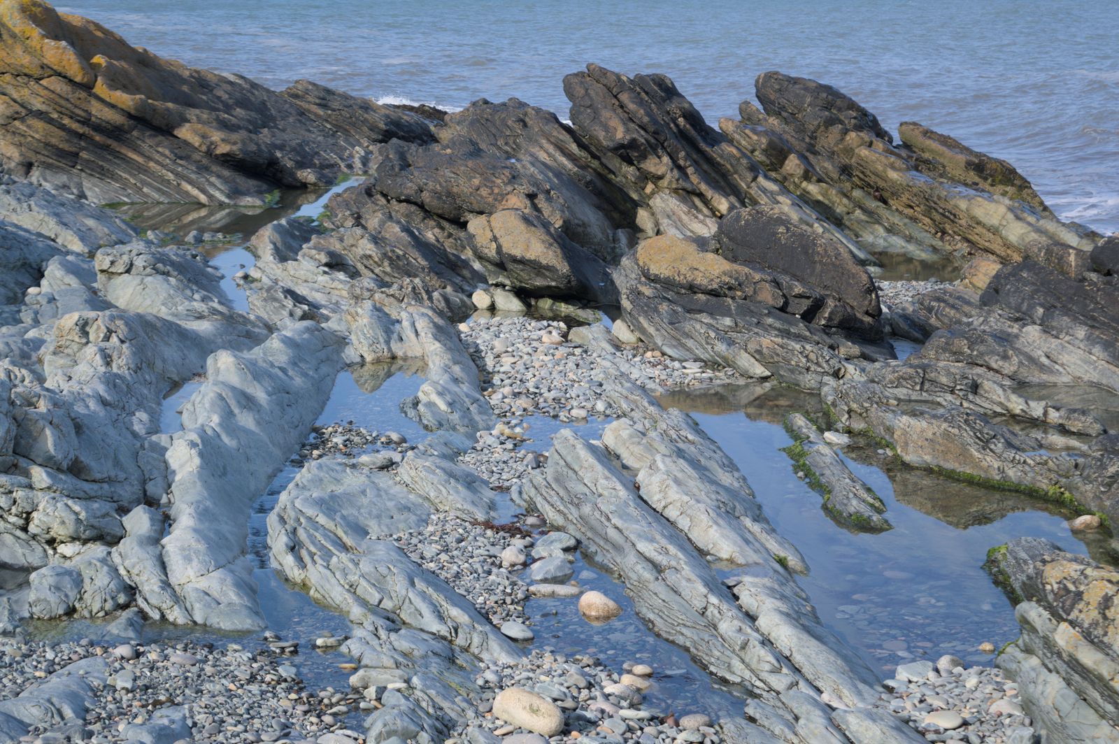 Rugged rocky shoreline of Newcastle, Northern Ireland with clear ocean views