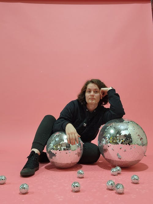 Woman with Disco Balls Posing on Pink Background
