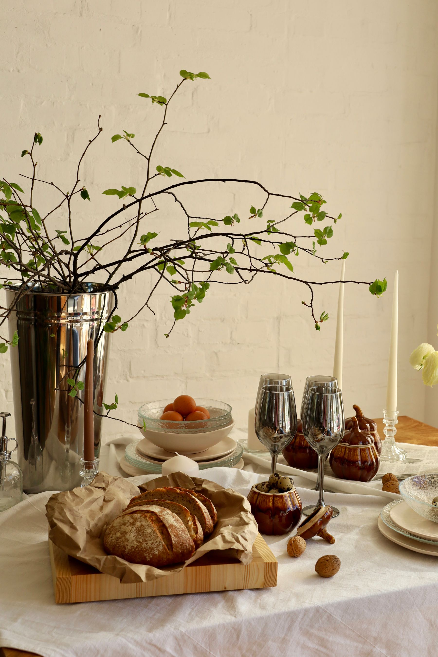 Curated home still life with ceramics, glassware, linen, wood, and soft natural light