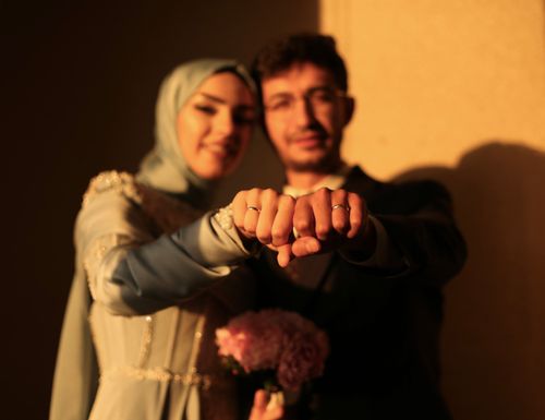 Free Newlywed couple proudly displaying wedding rings with a warm, intimate focus Stock Photo
