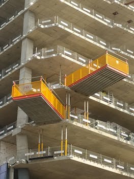 Close-up of a building under construction in Warsaw, showcasing balconies and scaffolding.