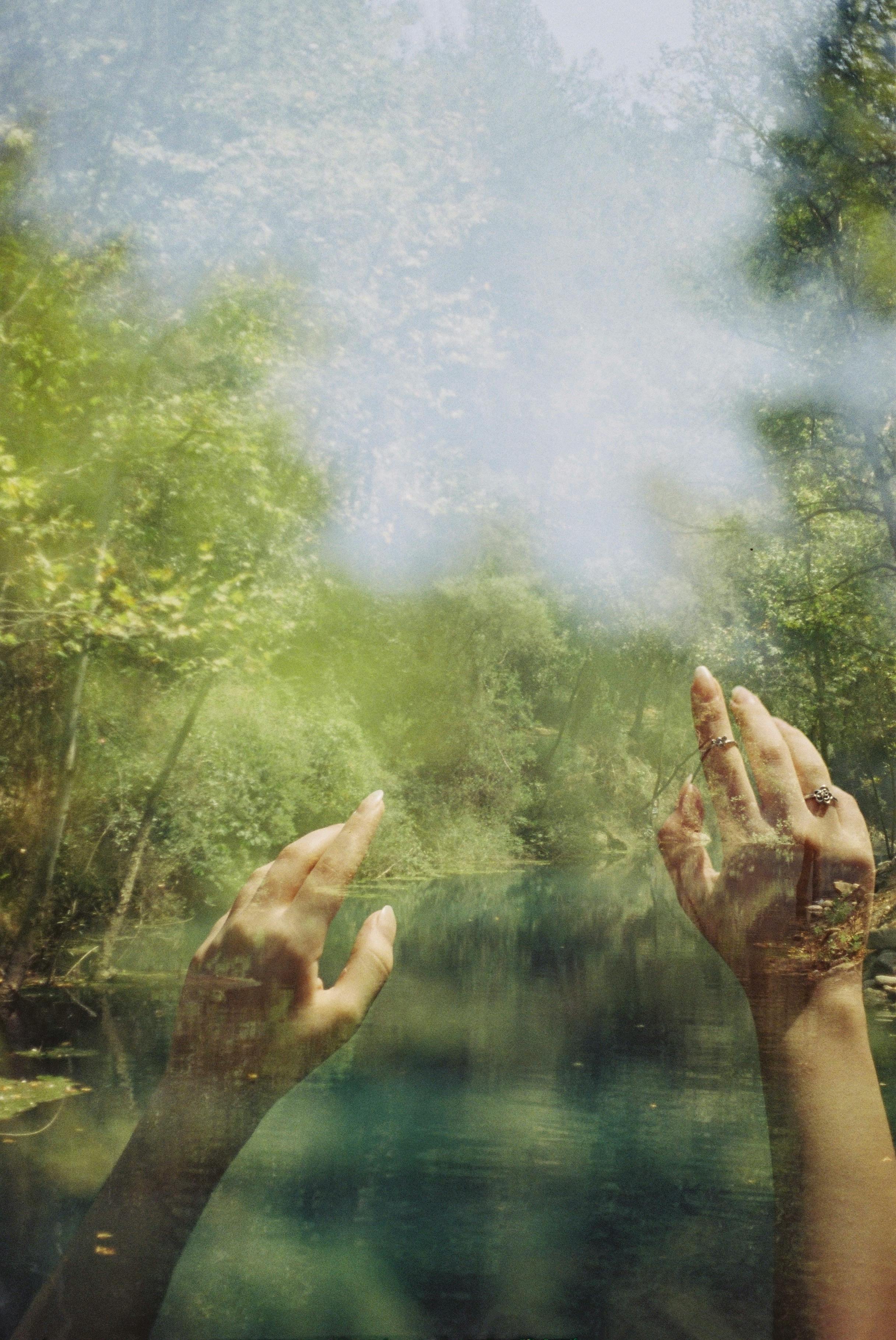 Artistic double exposure with hands and lush forest in Aladağ, Türkiye.