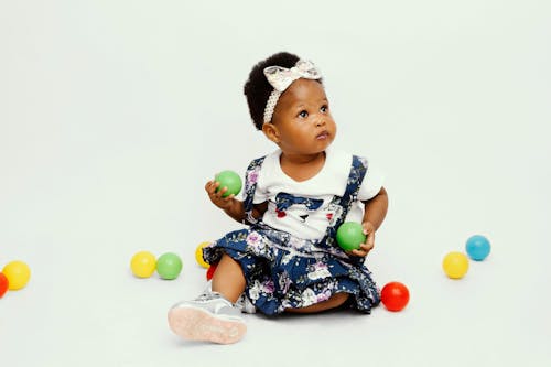 Free Studio Shot of a Little Girl Holding Colorful Balls  Stock Photo