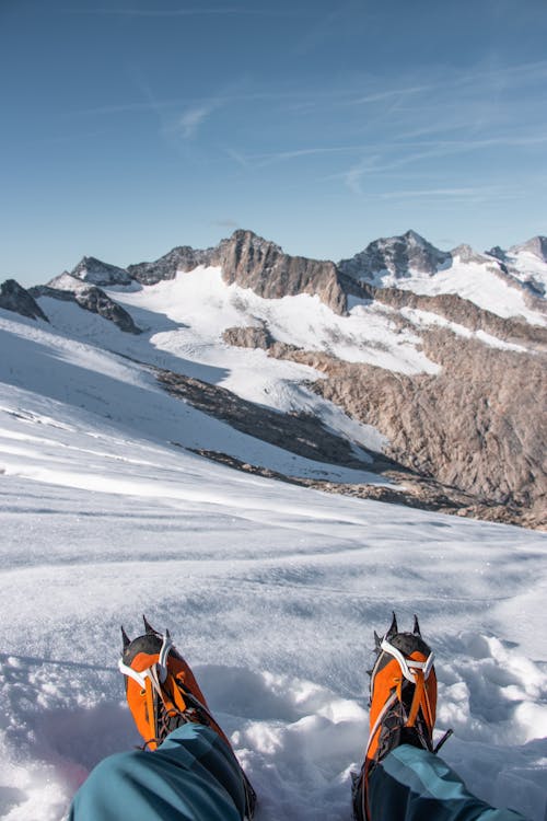 Shoes of Person Sitting on Snow in Mountains