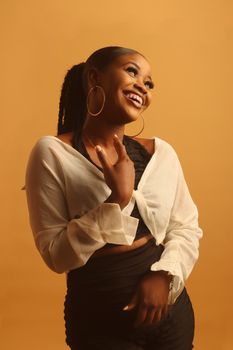 Beautiful woman in trendy fashion, smiling against a warm background.