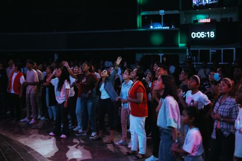 Free Diverse group of people enjoying a lively concert indoors with vibrant lighting. Stock Photo