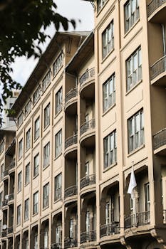 Close-up of a classic urban apartment building facade with multiple balconies and windows.