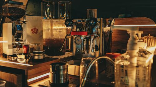 Free A cozy café counter featuring a modern espresso machine and coffee accessories. Stock Photo