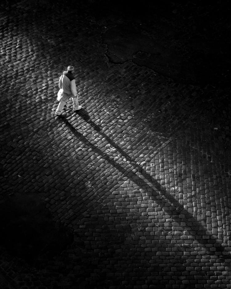 Man Walking On A Cobblestone Square