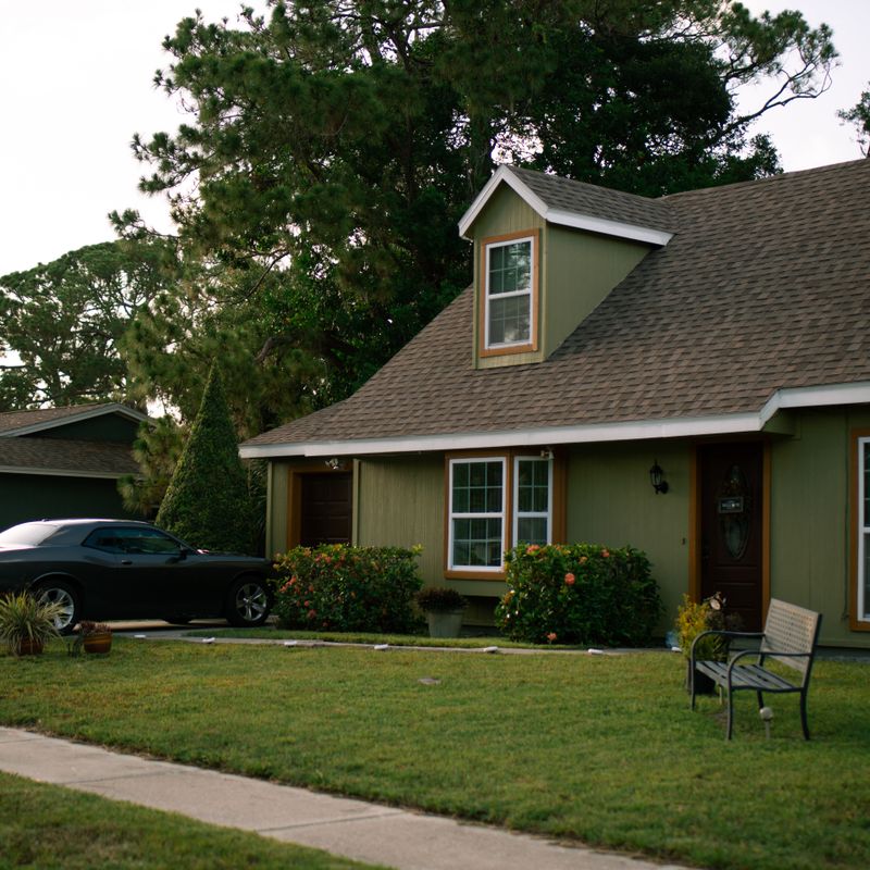 Suburban home with a green lawn and a car parked in the driveway