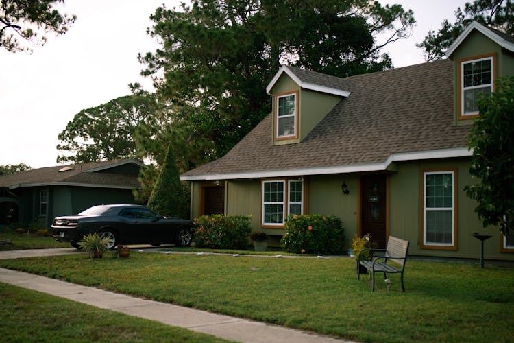 Residential House And A Car Parked In The Driveway