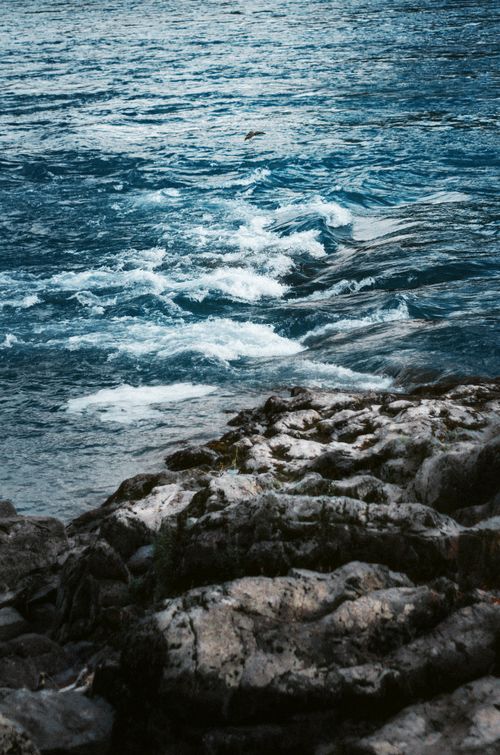 Free Dynamic waves crash over an eroded rocky shoreline, showcasing nature's raw beauty. Stock Photo